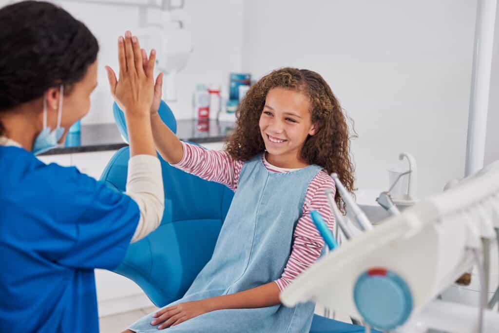 Smiling,Girl,Giving,High,Five,To,Dentist,After,Dental,Checkup